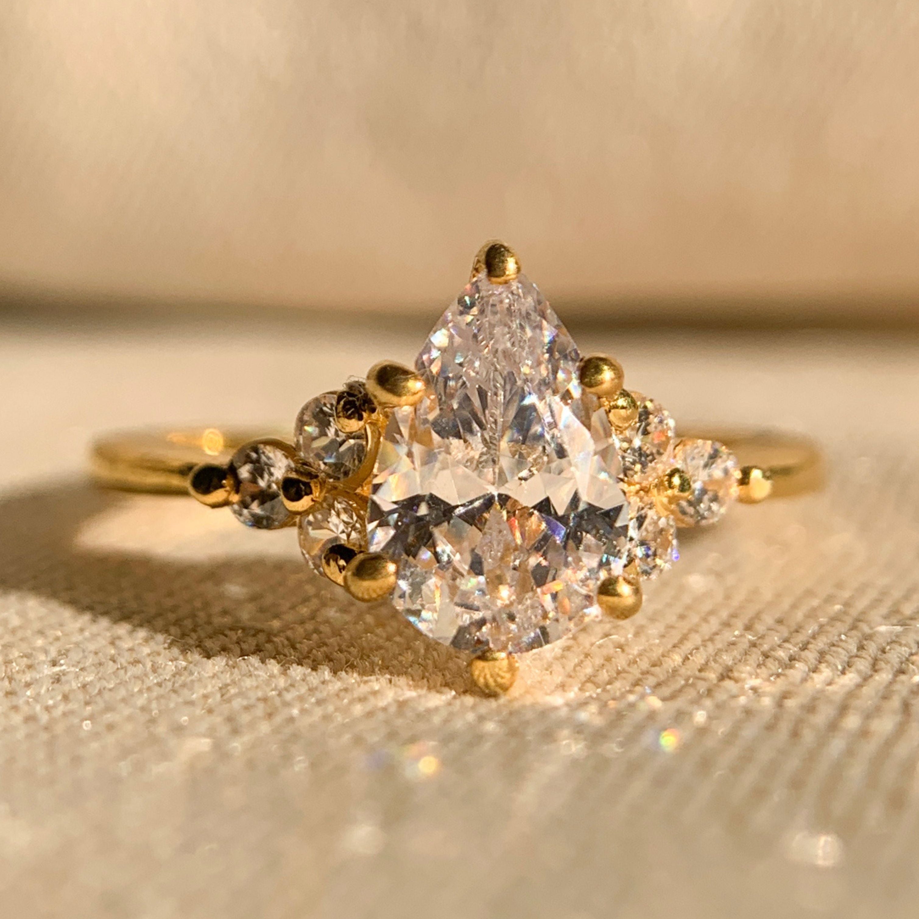 Elegant pear cut engagement ring with side stone settings in white gold